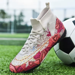 Tempesta Men’s Firm Ground Football Boots in white with pink sole and colourful crack details shown on a football pitch next to a ball