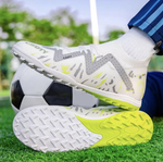 Galactic Men’s Turf Football Boot white patterned on foot next to a football on green artificial grass field background