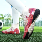 Tempesta Men’s Turf Football Boots in white with pink graphic details worn on artificial grass field with a football in the background
