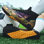 Tempesta Men’s Turf Football Boots in black with gold graphic details worn on artificial grass field with a football in the background
