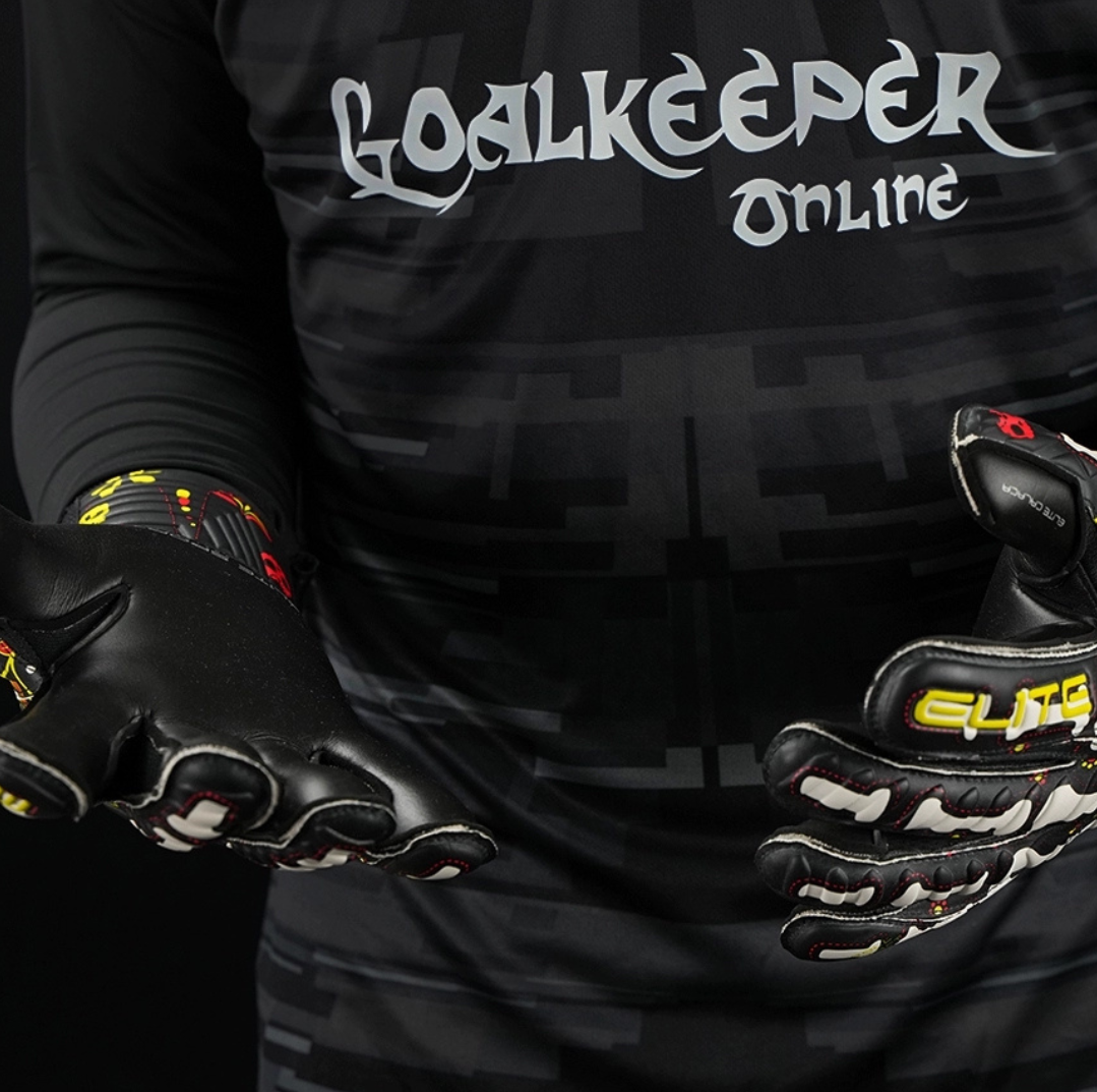 Football goalkeeper wearing Elite Sport Pro Calavera gloves adjusting wrist strap on black patterned background