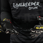 Football goalkeeper wearing Elite Sport Pro Calavera gloves adjusting wrist strap on black patterned background