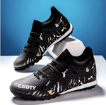 Pair of Galactic Men’s Turf Football Boots black patterned on white stand with blue gradient background