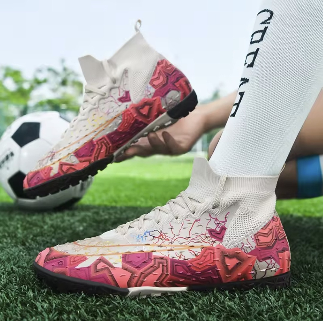 Tempesta Men’s Turf Football Boots in white with pink graphic details worn on artificial grass field with a football in the background