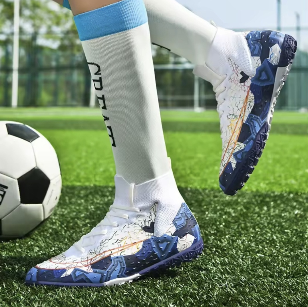Tempesta Men’s Turf Football Boots in white with blue graphic details worn on artificial grass field with a football in the background