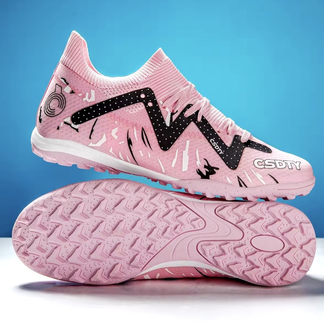 Pair of Galactic Men’s Turf Football Boots pink patterned on white stand with blue gradient background