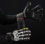 Football goalkeeper wearing Elite Sport Pro Calavera gloves adjusting wrist strap on black patterned background