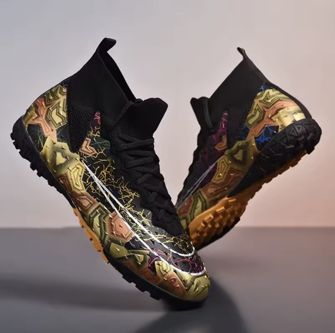 Tempesta Men’s Firm Ground Football Boots in black with gold sole and colourful crack design displayed on a reflective surface