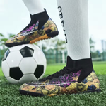 Tempesta Men’s Turf Football Boots in black with gold graphic details worn on artificial grass field with a football in the background