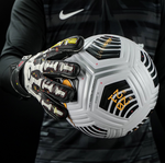 Goalkeeper holding football with Elite Sport Pro Calavera gloves featuring skeleton and floral details on black background